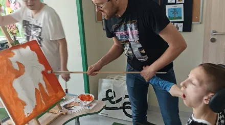 Olek podczas malowania konia z pomocą pana Daniela