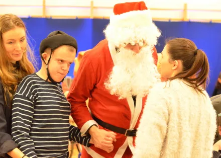 22. Nauczyciel przebrany za Świętego Mikołaja trzyma za rękę jednego z uczniów. Obok stoją dwie nauczycielki