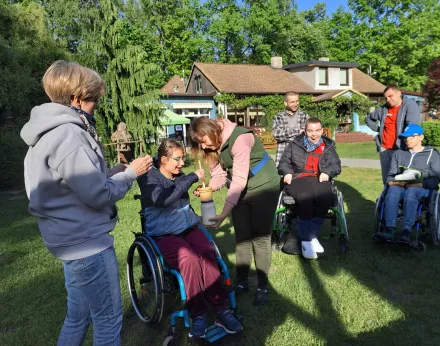 Uczennica robi masło. Koledzy i dorośli patrzą na dziewczynkę