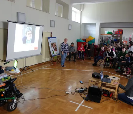 Na ekranie w sali gimnastycznej pojawiają się zdjęcia pani Hani – uczniowie zapoznają się z postacią naszej Patronki