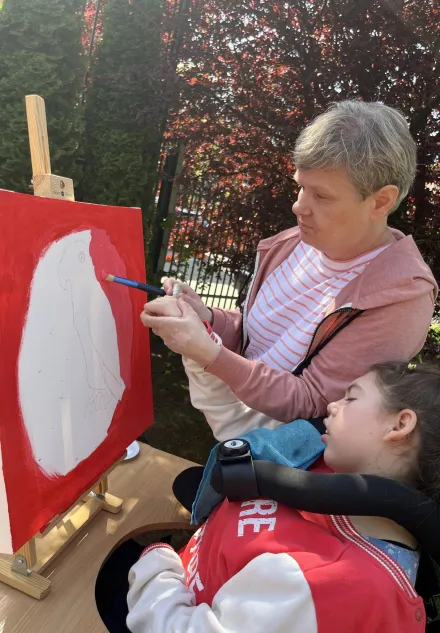 Uczennica Marysia podczas malowania z panią Ulą na warsztatach malarskich w plenerze