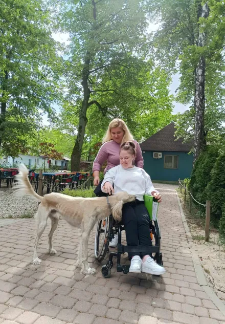 Uczennica i nauczycielka głaszczą psa