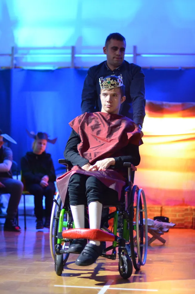 7. Uczeń przebrany za króla ma na głowie koronę. Razem z Panem Asystentem stoi na tle szopki