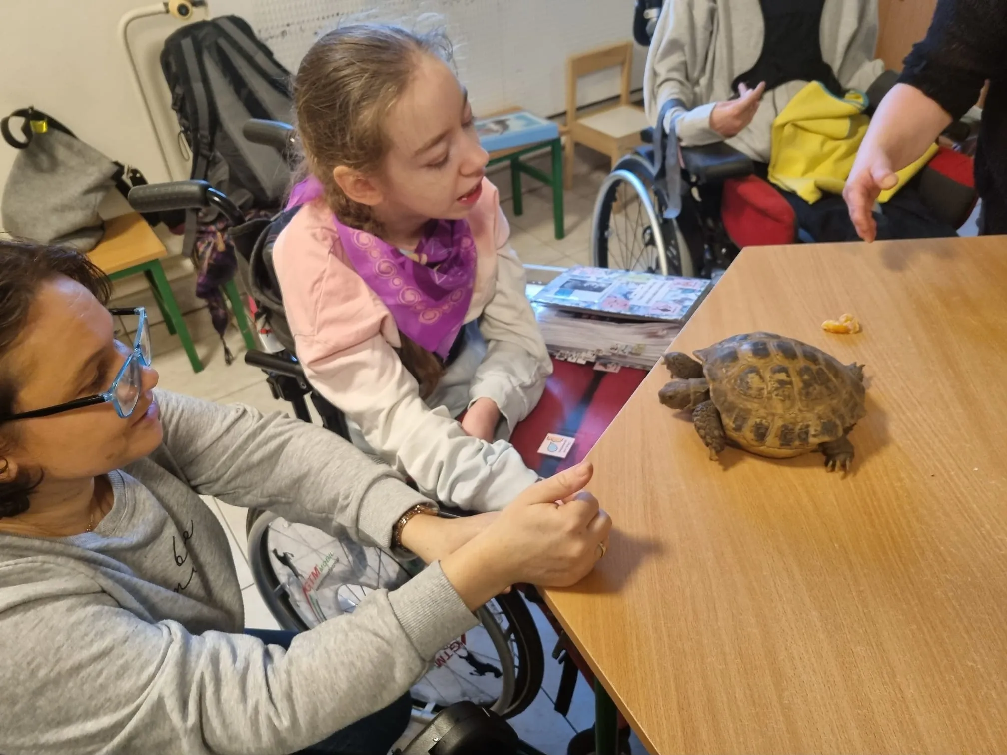 Uczennica z wychowawcą przyglądają się żółwiowi